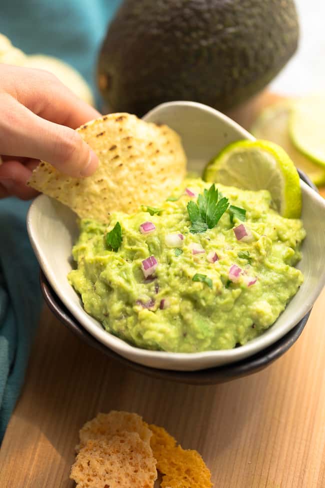 Homemade Guacamole - this quick and simple recipe is the perfect easy party dip with tortilla chips or along with tacos or by the spoonful. Best of all, only 6 ingredients to make for your next Mexican-inspired meal.