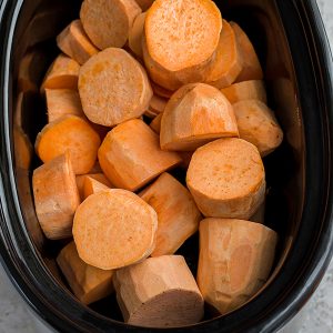 Top view of raw sweet potato rounds in a slow cooker