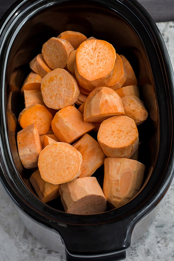 Top view of raw sweet potato rounds in a slow cooker