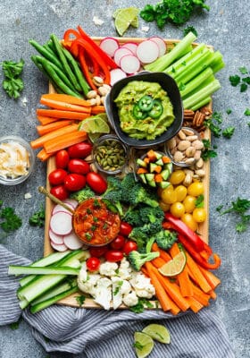 Top view of a vegan Whole30 veggie platter on a wooden tray on a grey background