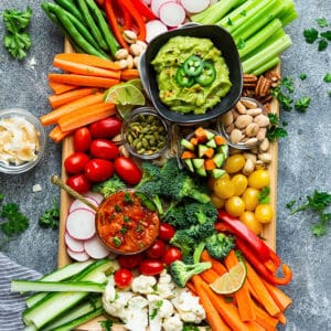 Top view of a vegan Whole30 veggie platter on a wooden tray on a grey background