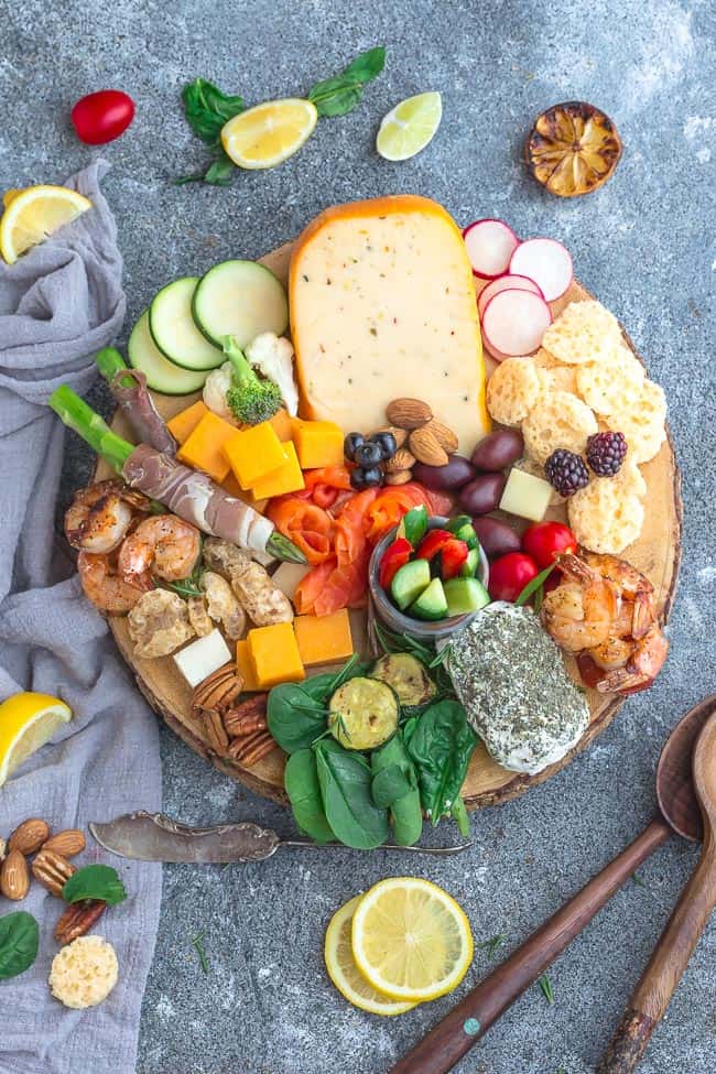 Overhead view of a cheese board surrounded by lemon slices 