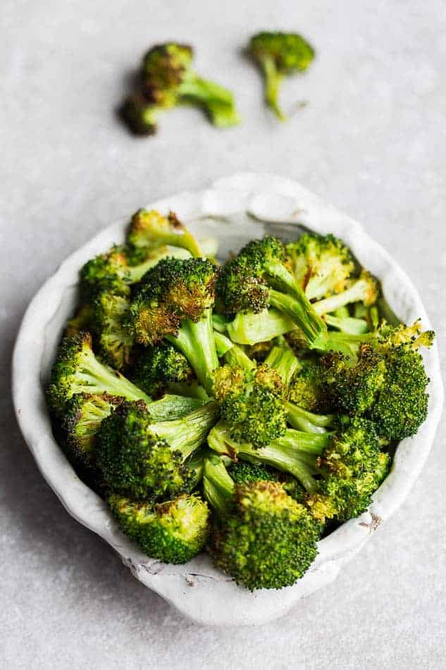 White bowl of roasted frozen broccoli