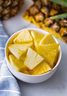Top view of chopped pineapple cubes in a white bowl