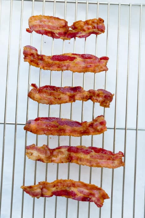 Top view of oven baked crispy paleo bacon on a cookie rack parchment paper