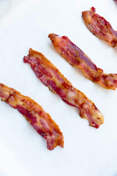 Top view of oven baked crispy bacon on parchment paper