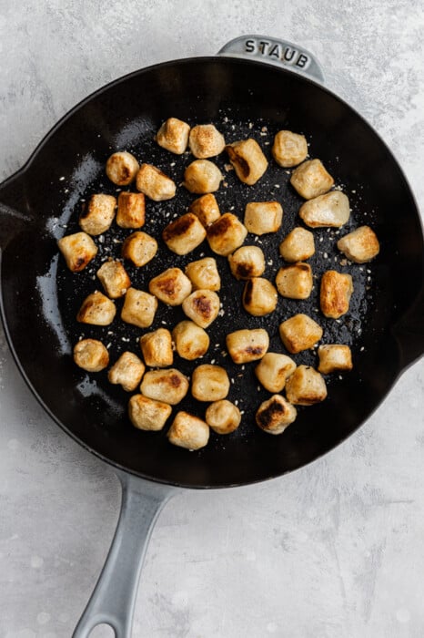 Top view of pan fried crispy cauliflower gnocchi on a nonstick pan