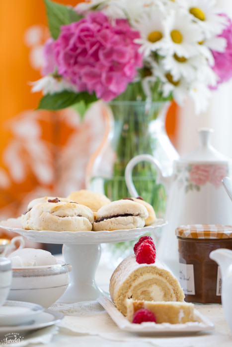 A pumpkin roll and biscuits on a table for a tea party