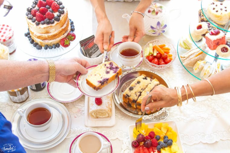 Blueberry Lemon Loaf cake being served over a table set with tea and treats for a tea party