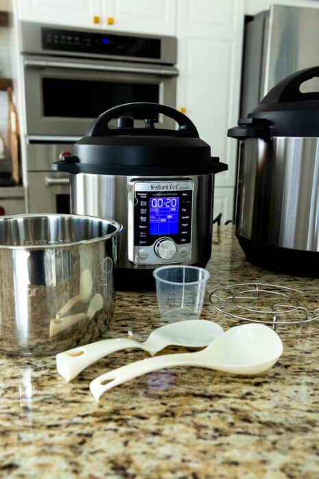 Side view of three Instant Pot pressure cookers plus accessories on a counter