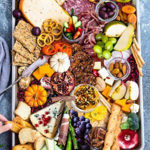 Top view of Fall Cheese Board with crackers, apples, pumpkins, pears, grapes, charcuterie etc.