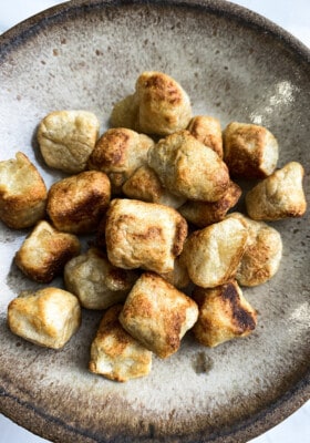 Close-up top view of the best cauliflower gnocchi on a beige plate