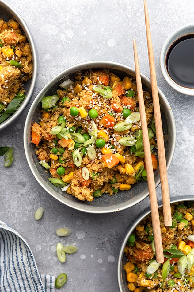 Top view of a bowl of easy cauliflower fried rice in a grey bowl with chopsticks