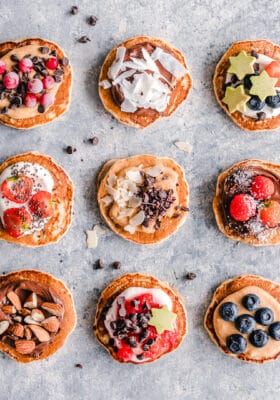 Top view of 9 fluffy pancakes with different toppings