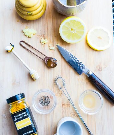 Top view of ingredients to make an immunity boosting shot - turmeric, honey, black pepper, lemon and apple cider vinegar