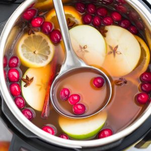 This Instant Pot Apple Cider Recipe is the perfect easy drink for fall and the holiday season. Best of all, made entirely in the pressure cooker with apples, orange, lemon, cranberries, cinnamon and cloves. Set and forget and makes your house smell amazing! Warm up with a mug by a cozy fireplace.