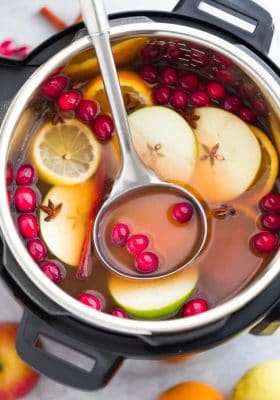 This Instant Pot Apple Cider Recipe is the perfect easy drink for fall and the holiday season. Best of all, made entirely in the pressure cooker with apples, orange, lemon, cranberries, cinnamon and cloves. Set and forget and makes your house smell amazing! Warm up with a mug by a cozy fireplace.