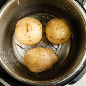 3 potatoes on a rack in an instant pot