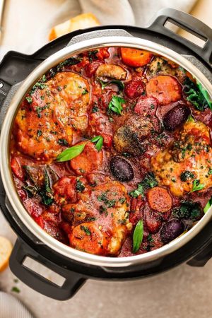 Tender chicken thighs, vegetables and herbs in a rich-tomato sauce in an Instant Pot.
