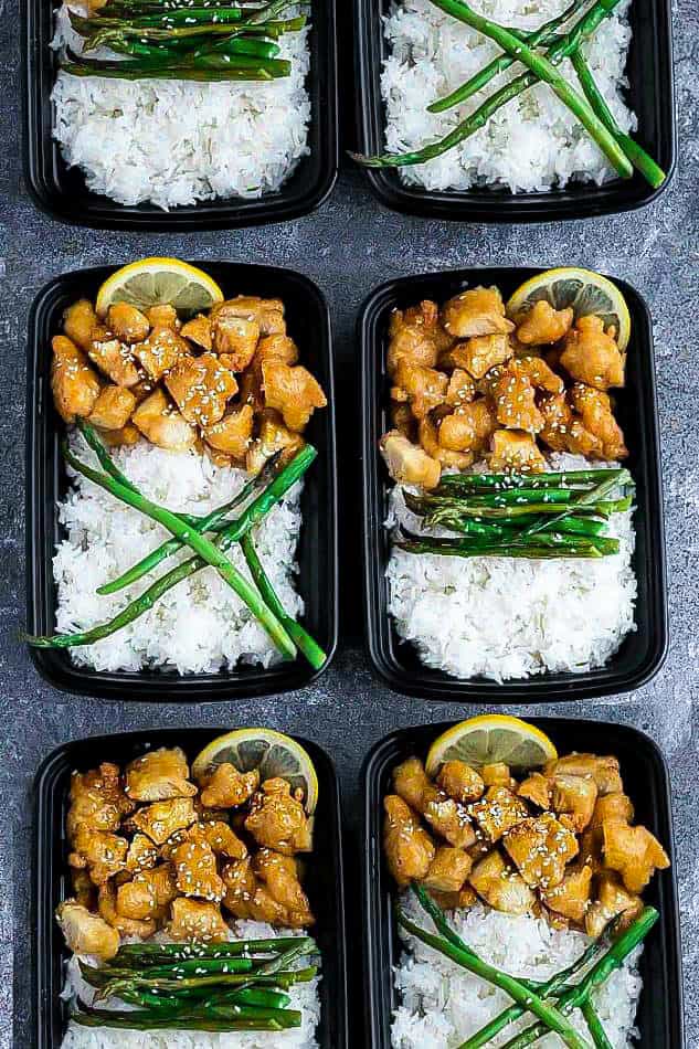 Top view of six meal prep containers of Chinese Lemon Chicken with rice and asparagus