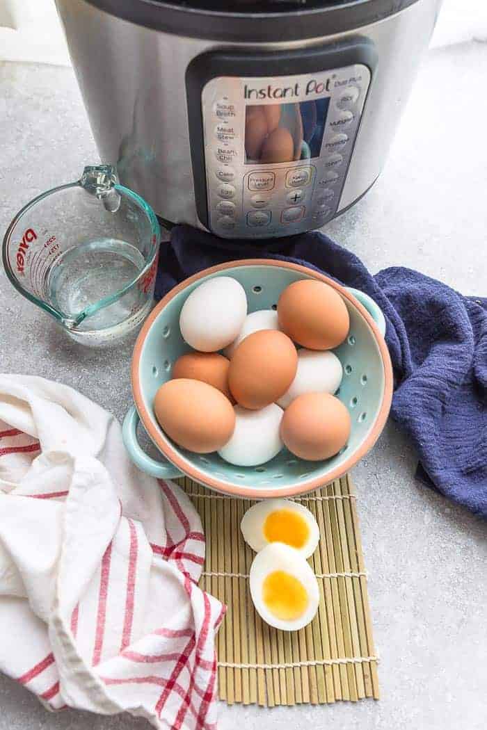 A Bowl of Hard Boiled Eggs Next to an Instant Pot and a Measuring Cup