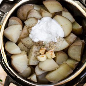 Top view of cut Russet potatoes and garlic in a pressure cooker