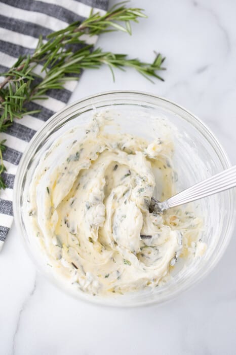 Top view of garlic herb butter in a clear bowl