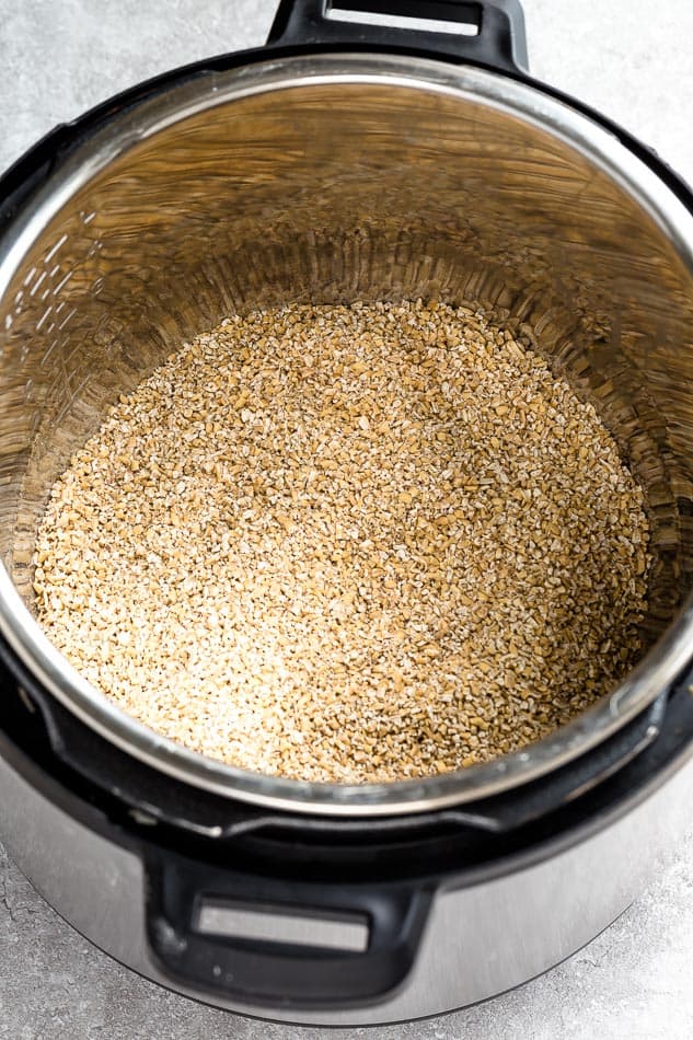 Top view of steel cut oats in a instant pot on a grey background