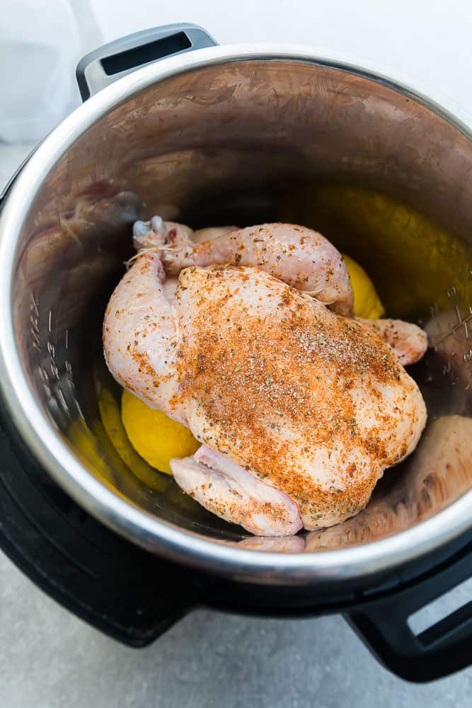 seasoned whole chicken waiting to be cooked in an electric pressure cooker