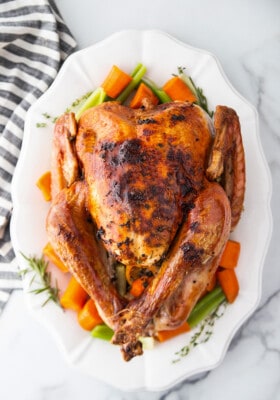 Top view of Instant Pot Whole Turkey on a white platter with vegetables