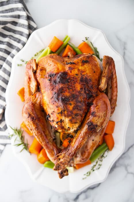 Top view of Instant Pot Whole Turkey on a white platter with vegetables
