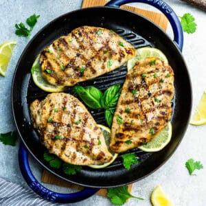 Three Grilled Chicken Breasts in a Cast Iron Skillet on a Countertop