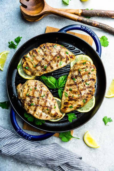 Three Grilled Chicken Breasts in a Cast Iron Skillet on a Countertop