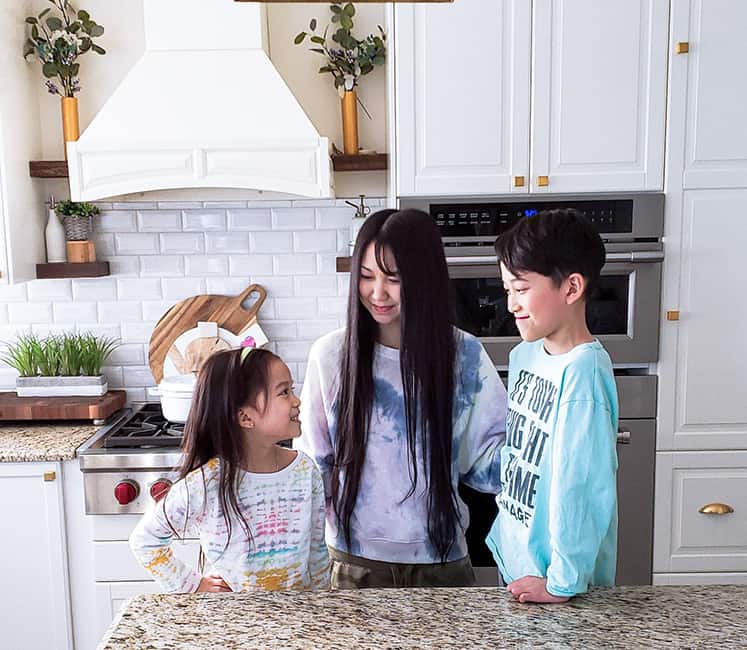 Kelly Kwok in her kitchen with two children