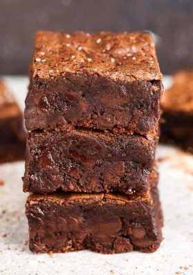 Side view of stacked Low Carb Paleo Keto Brownies on parchment paper
