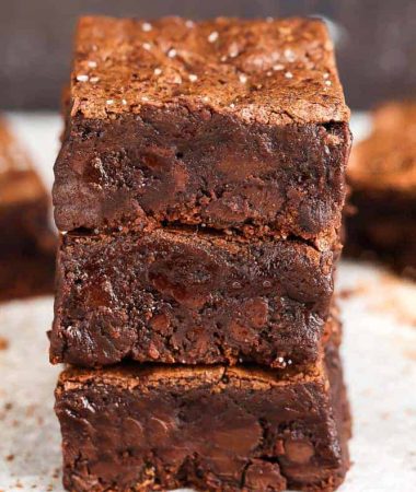 Side view of stacked Low Carb Paleo Keto Brownies on parchment paper
