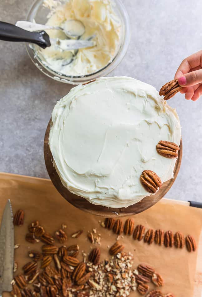 Frosted carrot cake layers with white frosting in a bowl