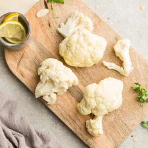 Top view of fresh cauliflower on a wooden cutting board