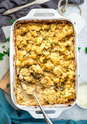 Top view of Vegan Cauliflower Mac and Cheese in a white baking dish with a serving spoon