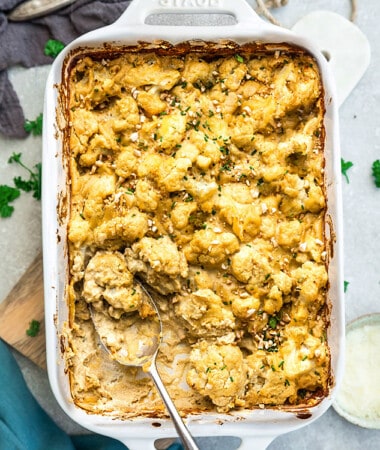 Top view of Vegan Cauliflower Mac and Cheese in a white baking dish with a serving spoon