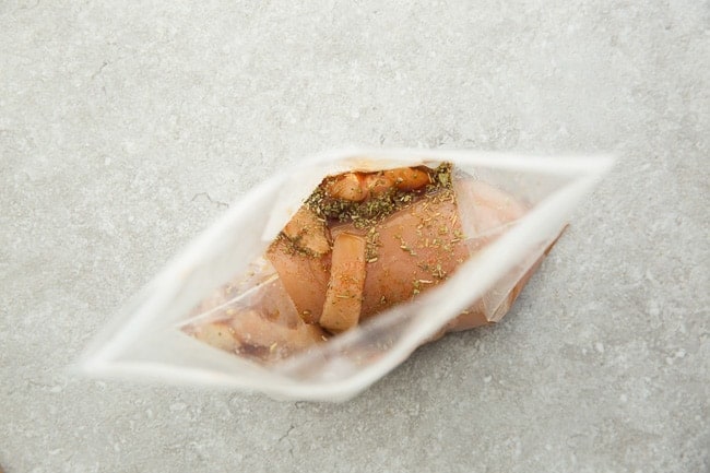 Top view of one chicken breast marinated chicken breast in ziplock bags