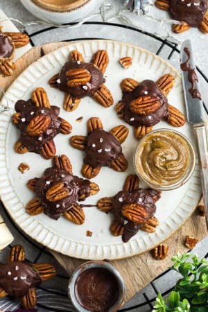 Top view of 6 chocolate turtles on a white plate