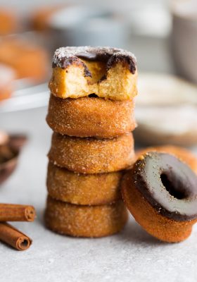5 Cinnamon Sugar Keto Donuts with chocolate frosting stacked on top of each other on a plate