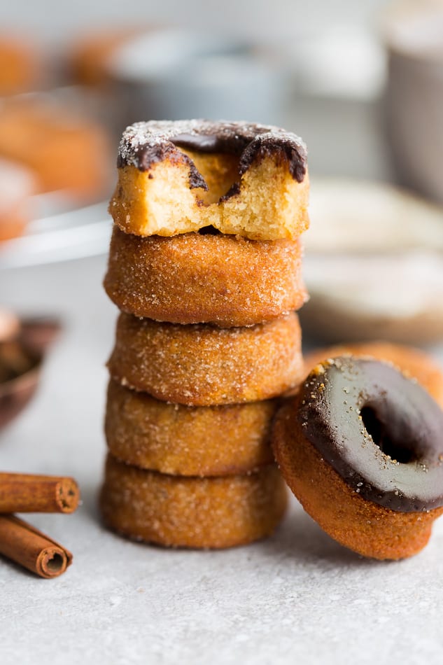 5 Cinnamon Sugar Keto Donuts with chocolate frosting stacked on top of each other on a plate
