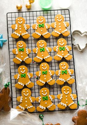 Top view of 12 decorated gingerbread men cookies on a cooling rack
