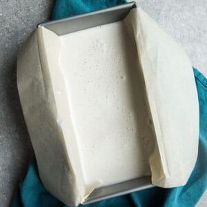 Top view of unfrozen Low Carb Keto Ice Cream in a loaf pan lined with parchment paper