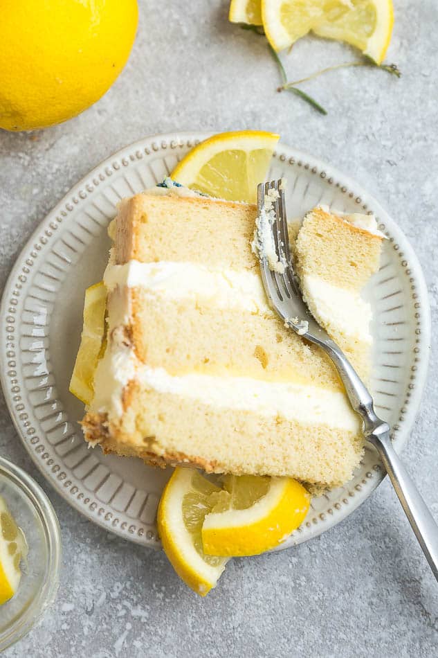 Close-up view of one slice of keto lemon cake on a white plate with a fork