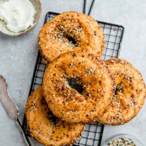 Top view of four Low Carb Keto Bagels with everything bagel seasoning on a grey background and a wire rack