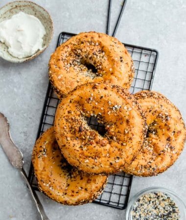 Top view of four Low Carb Keto Bagels with everything bagel seasoning on a grey background and a wire rack