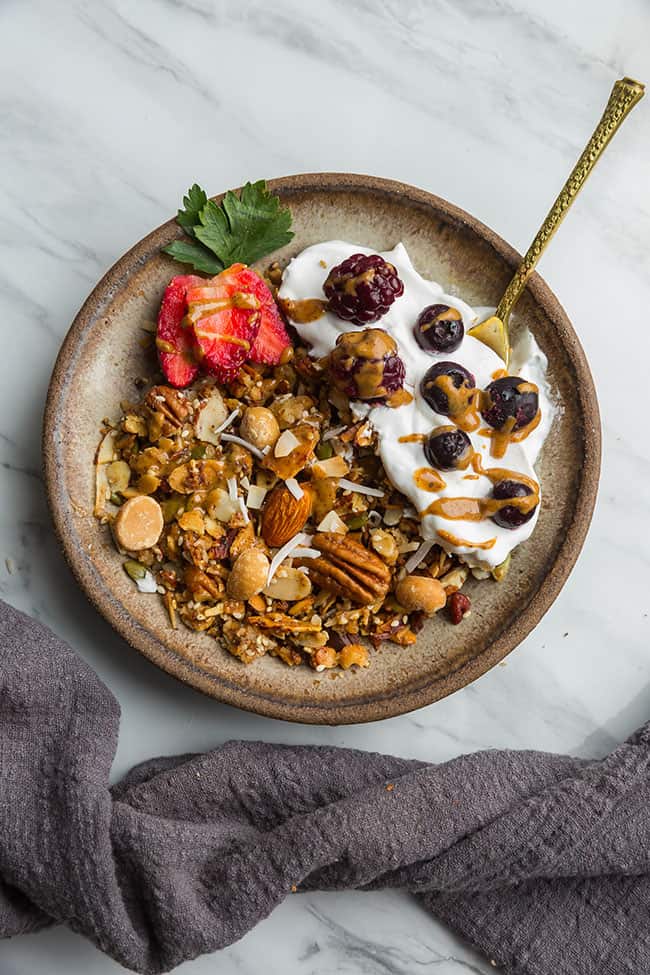 Top view of a bowl of granola with yogurt fruit and nuts